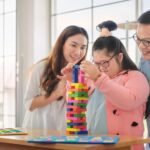 Child with Down syndrome supported by parents in occupational therapy activity in Darwin NT.